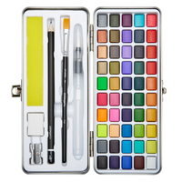 A set of 69 differently colored watercolor paint pans inside a white and black metal case, including 2 brushes, a pencil, eraser, sharpener, and sponge.