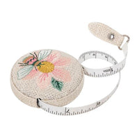 Retractable measuring tape with floral bee design on a white background