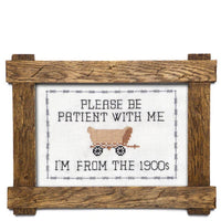 Decorative sign with a wooden frame, featuring text and a vintage-style illustration of a covered wagon.