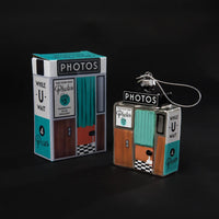 Decorative photo booth ornament with packaging on a black background