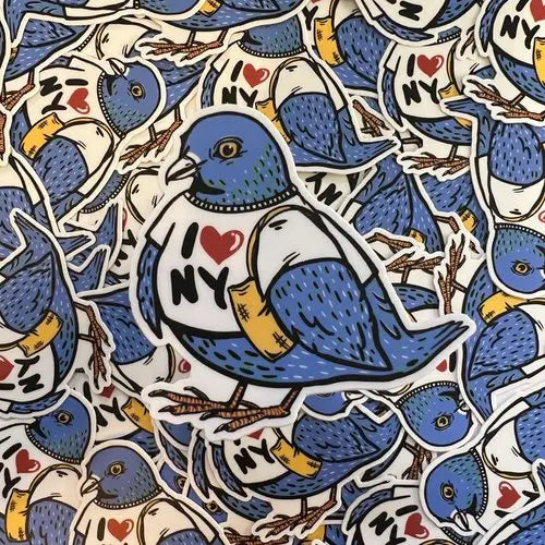 Pile of stickers in the shape of a blue pigeon wearing an I heart NY shirt and carrying a tote bag.