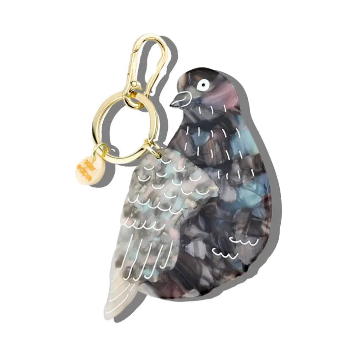 Charm in the shape of a gray pigeon on a gold keychain ring.