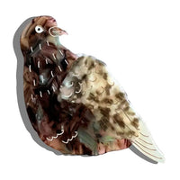 Hair claw clip in the shape of a gray pigeon.