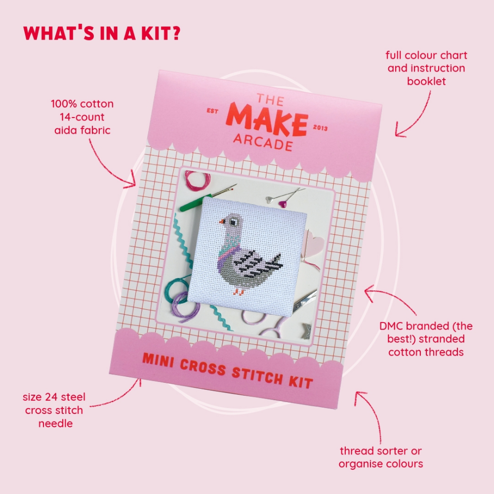 A square white cross-stitch canvas featuring a gray pigeon design  packaged in pink with the title "The Make Arcade: Mini Cross Stitch Kit", with features about the kit listed around packaging.