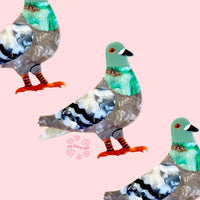 multiple pigeon brooches on a pink background