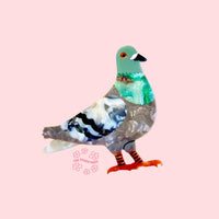 pigeon brooch on a pink background