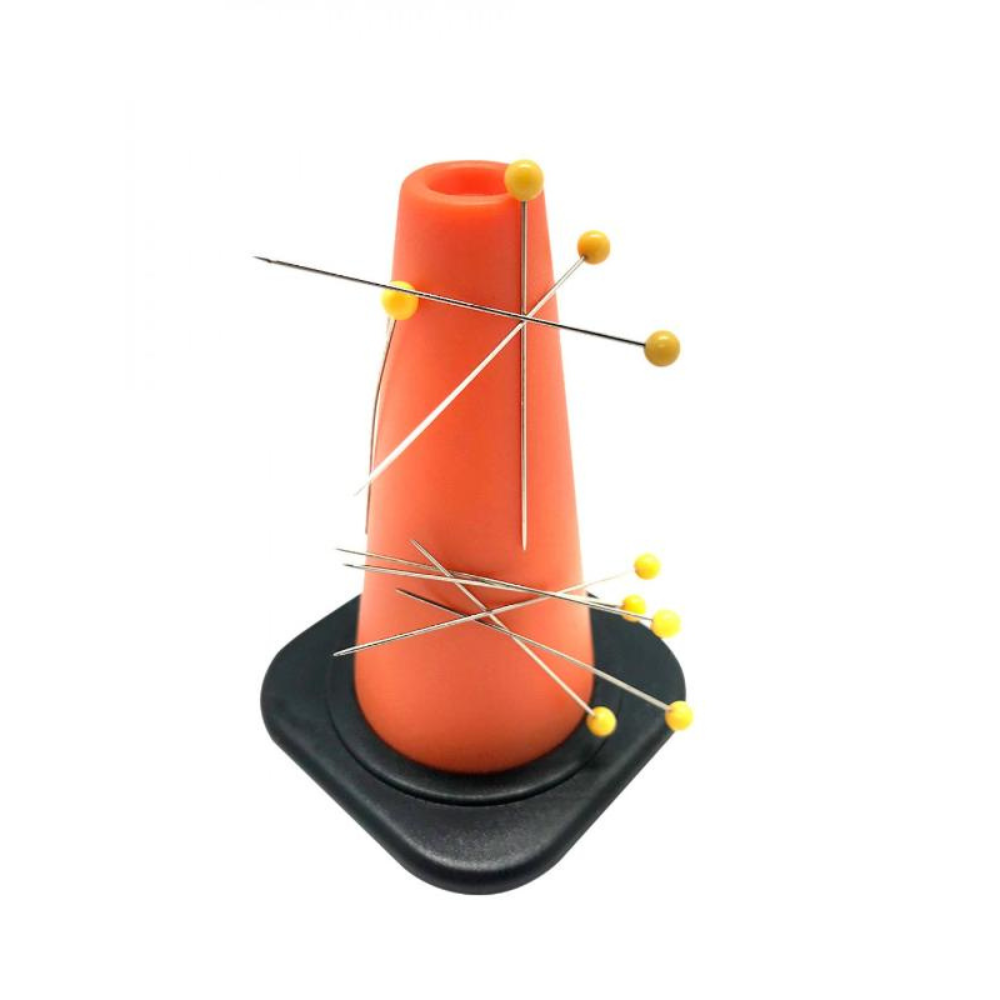Yellow pins on a mini orange traffic cone on a white background.