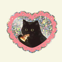 Heart shaped glittery sticker with a black cat eating a slice of pizza