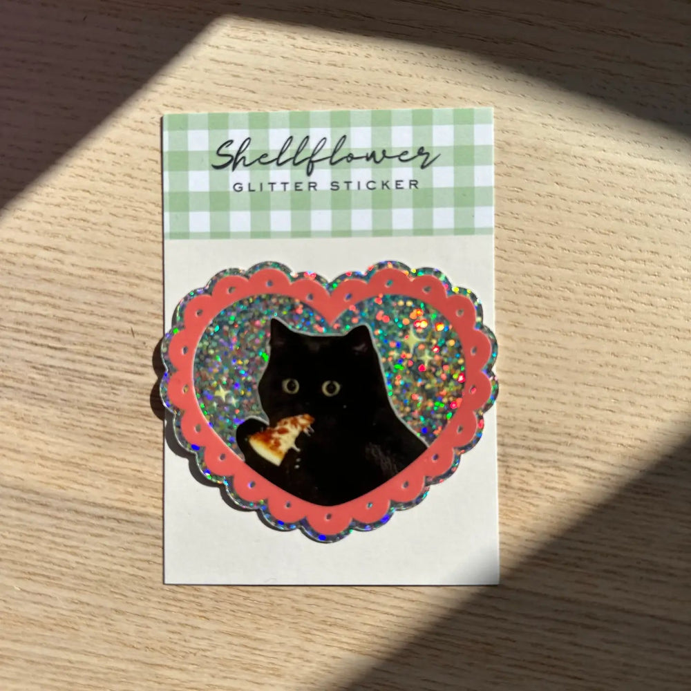 Glitter sticker with a black cat design on a wooden background