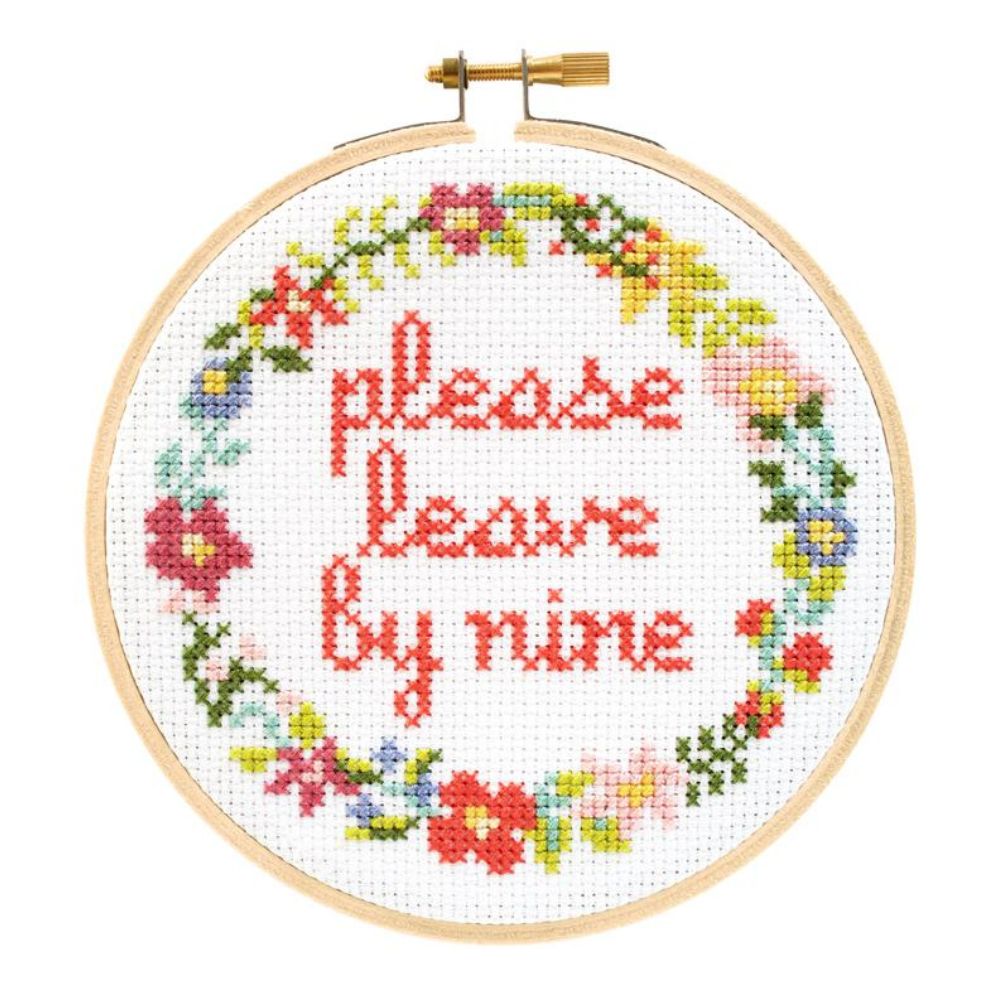Cross-stitched hoop with floral design and text 'please leave by nine' on a white background
