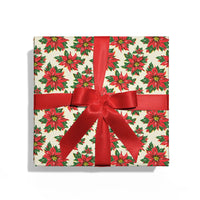 Gift box with poinsettia pattern and red ribbon on a white background