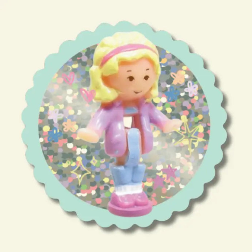 Toy figure with blonde hair and pink outfit on a decorative glitter background
