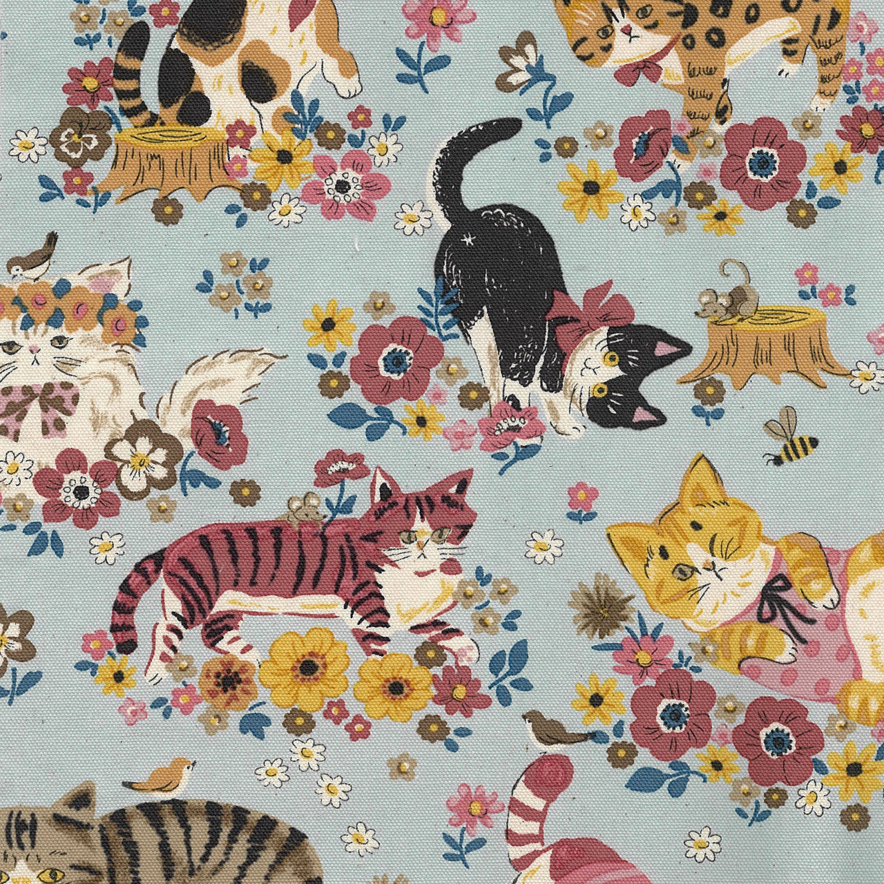 Fabric pattern with cats, flowers, and birds on a blue background