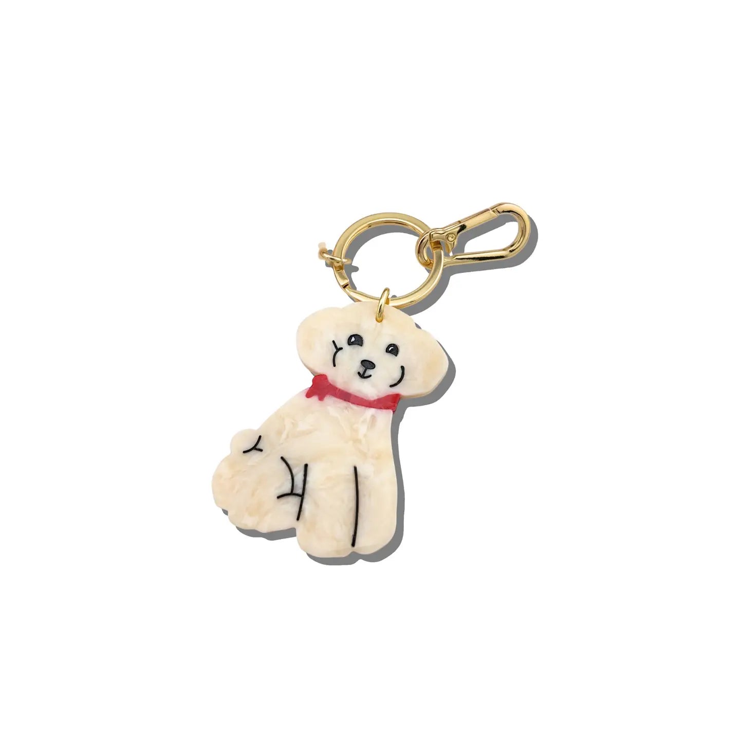 Charm in the shape of a white dog attached to a gold keychain ring.
