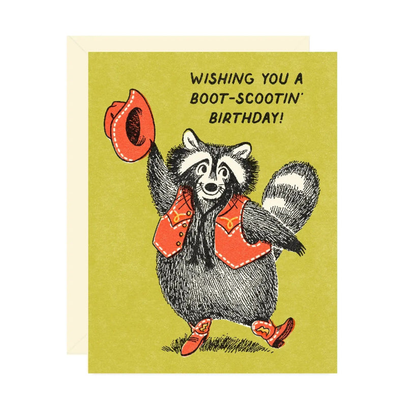 Birthday card with a raccoon illustration and text "Wishing You A Boot- Scootin Birthday" on a green background
