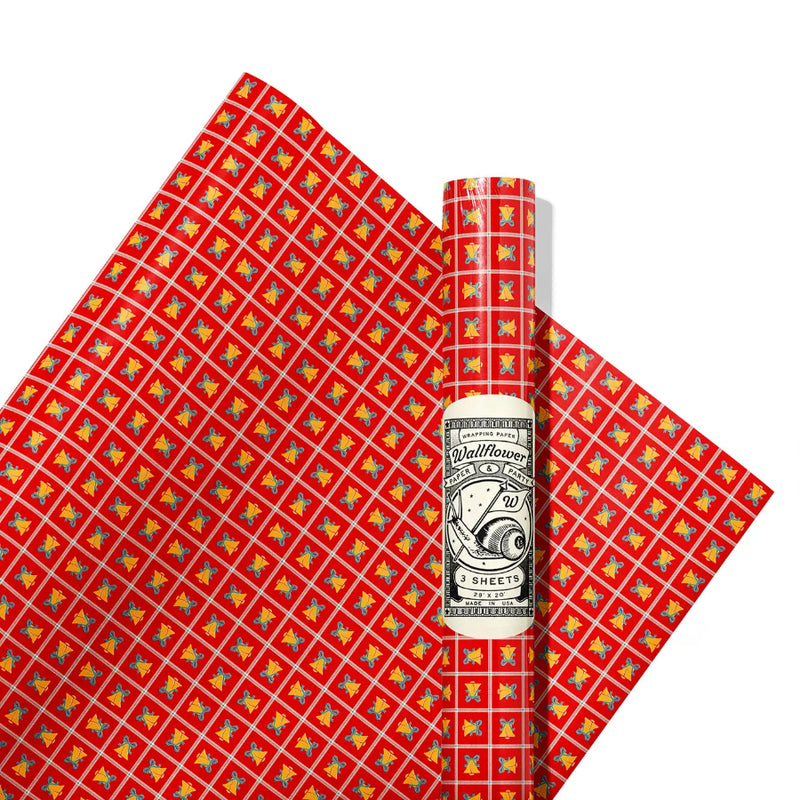 Red wrapping paper with colorful pattern and a roll of paper on a white background