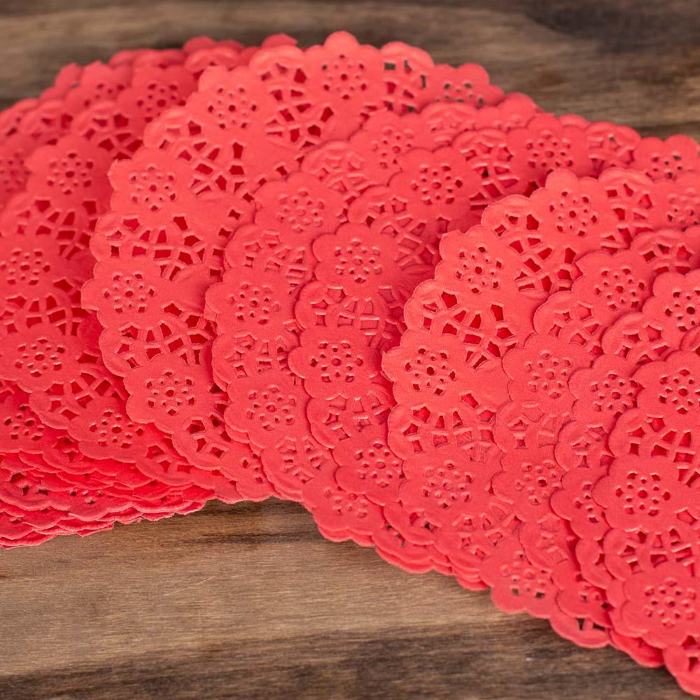 Stack of red lace doilies on a wooden surface