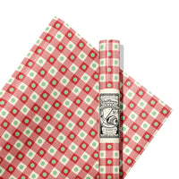 Red and green checkered paper with a roll of paper on a white background