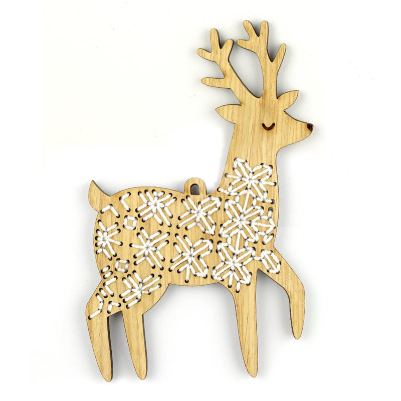 Wooden deer ornament with snowflake patterns on a white background