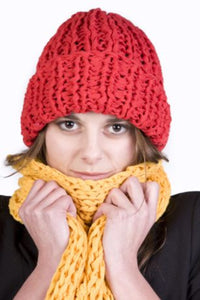 Person wearing a red knitted hat and yellow scarf on a white background