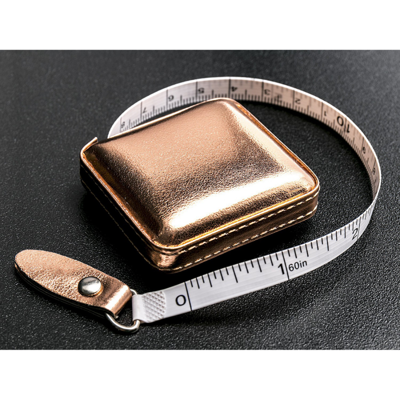 Bronze-colored tape measure with a metallic case on a black background
