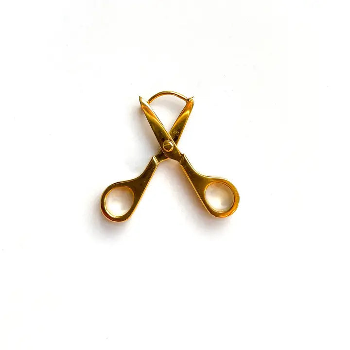 Gold scissor earrings on a white background