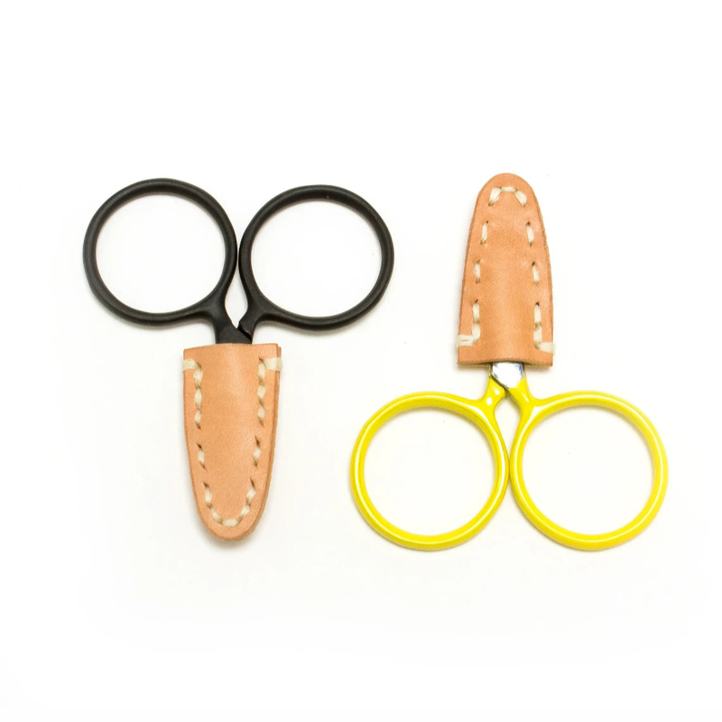 Black and yellow handled scissors with natural colored leather sheath covering both points