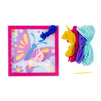 Colorful yarn and needle set with a patterned board on a white background