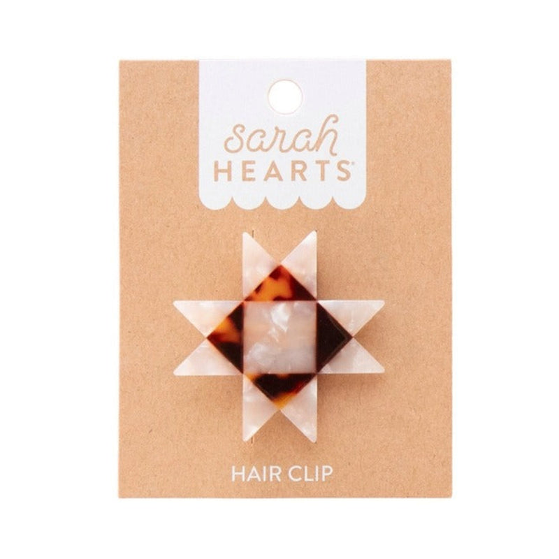 Geometric star hair clip packaging with 'Sarah Hearts' branding on a beige background