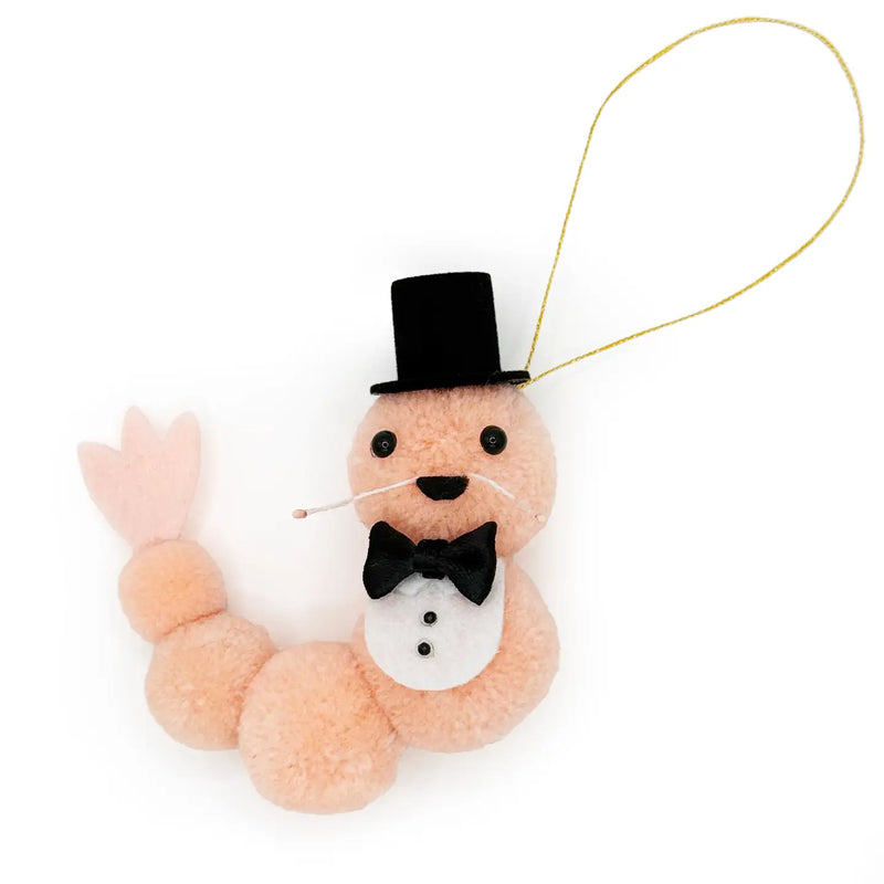Pink shrimp wearing a tuxedo pom pom ornament on a white background.