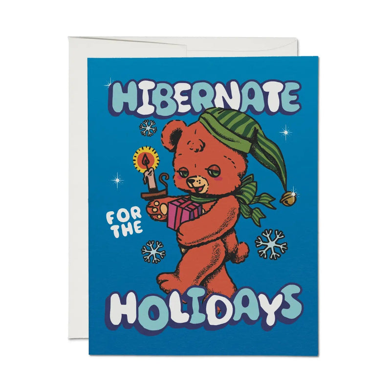 Greeting card with a bear holding a gift and 'Hibernate for the Holidays' text on a blue background.