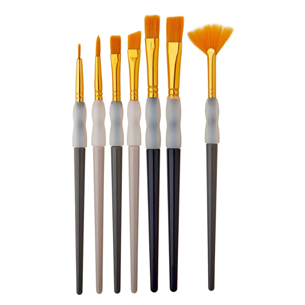 7 paintbrushes with assorted neutral colored handles and gold bristles on a white background