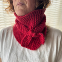 Person wearing a red knitted scarf on a white background