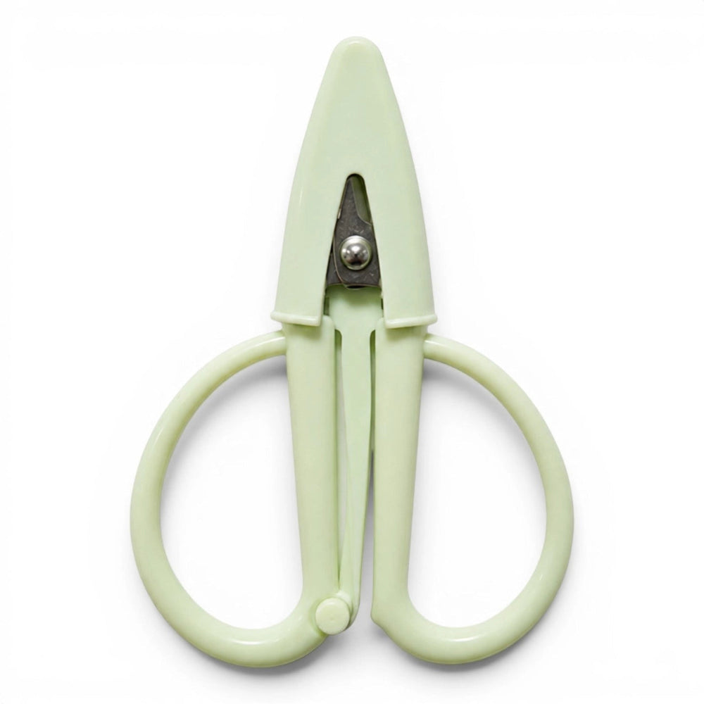 A small pale green pair of scissors with a matching point protector on a white background