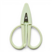 A small pale green pair of scissors with a matching point protector on a white background