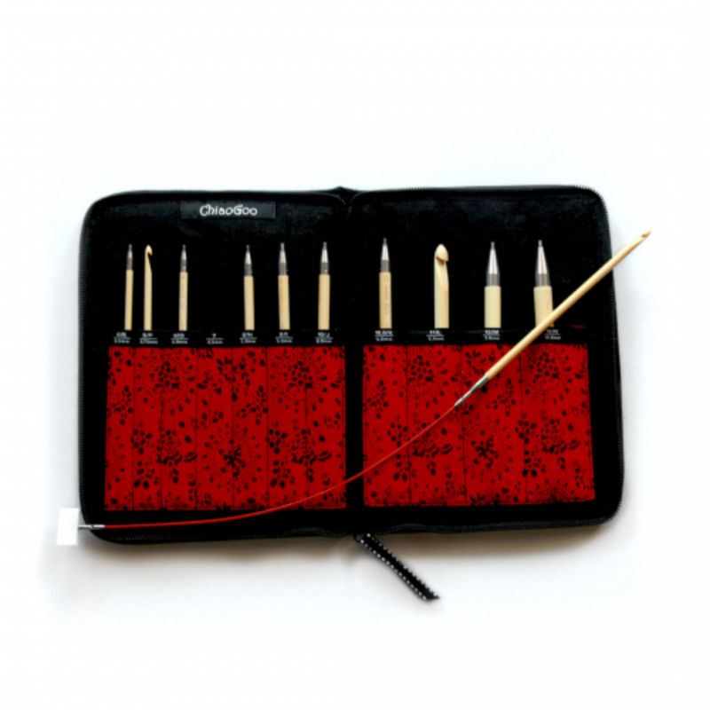 Set of tunesian crochet hooks in a black case with red interior on a white background