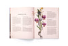 Open book with illustrated flowers and text on a white background