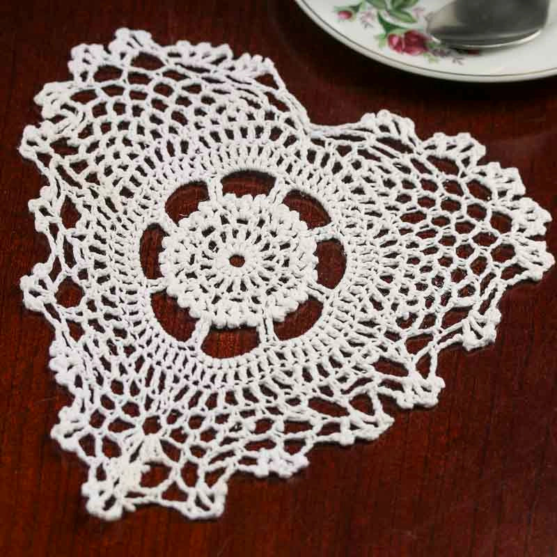 White crocheted doily on a wooden surface