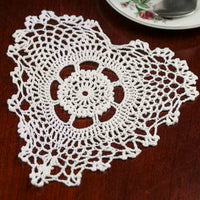 White crocheted doily on a wooden surface
