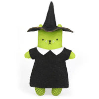 A felt cat toy dressed in a witch costume, featuring a green body, a black dress with a white collar, and a black witch hat, set against a plain white background.
