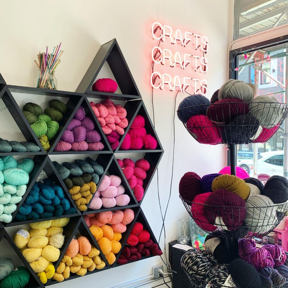 Wall display with triangle shelves full of colorful yarn